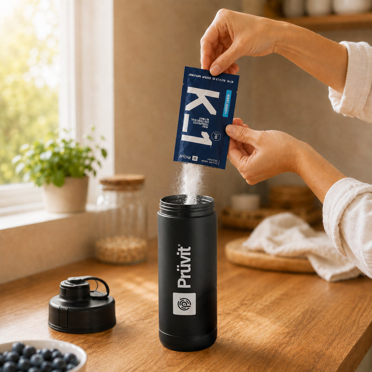 Pouring a sachet of K_1 into a shaker bottle on a kitchen counter